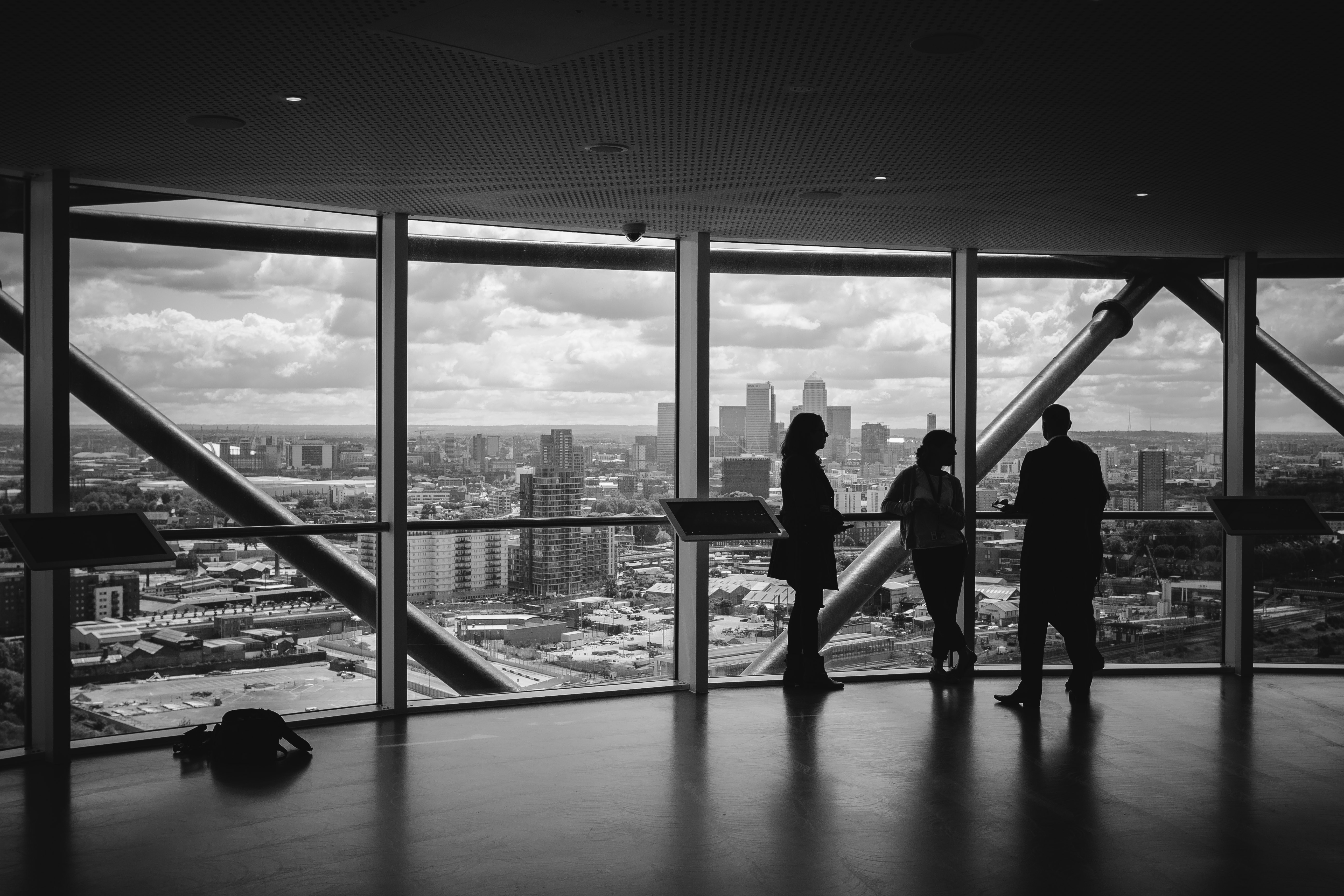 Business travelers silhouetted against a panoramic city skyline from a high-rise