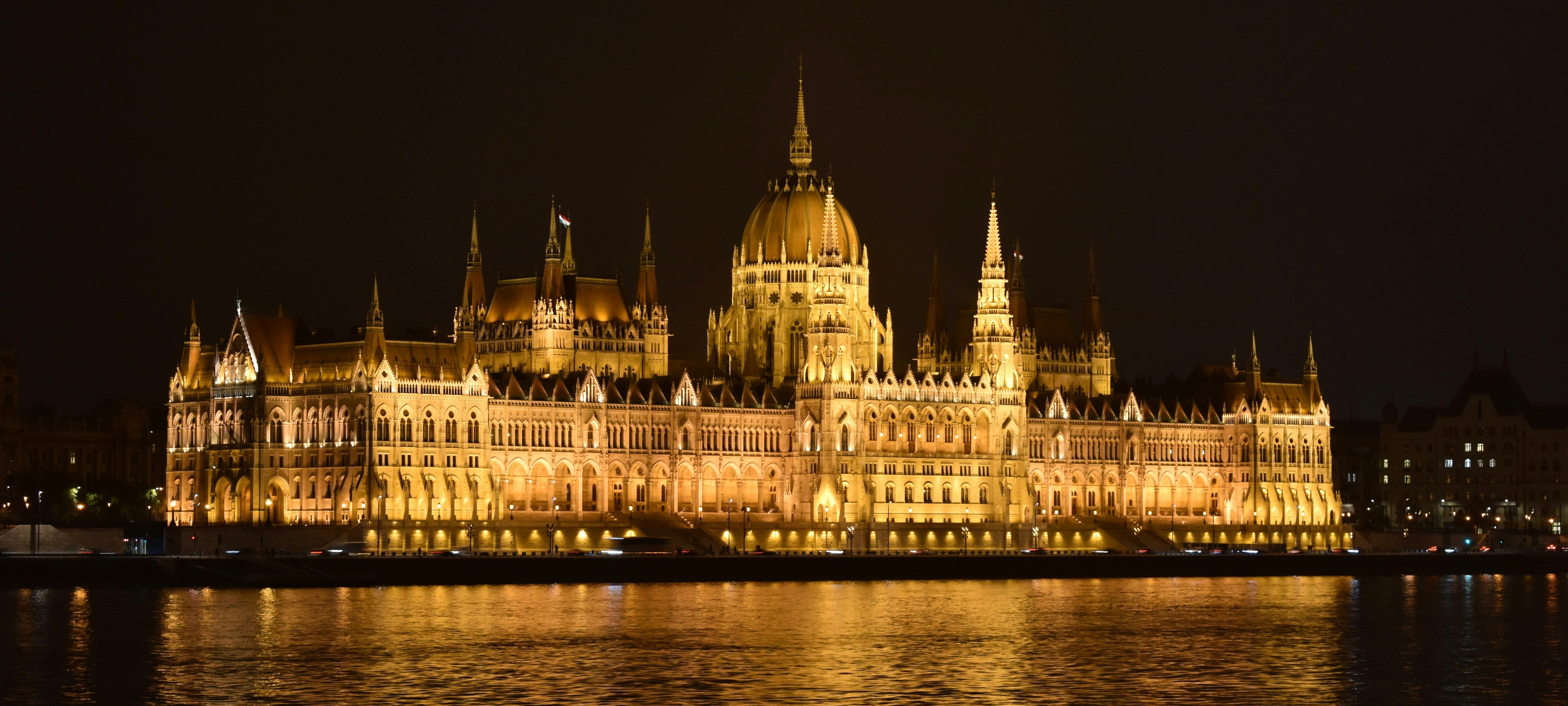 Hungarian Parliament Building illuminated at night reflecting in the Danube River