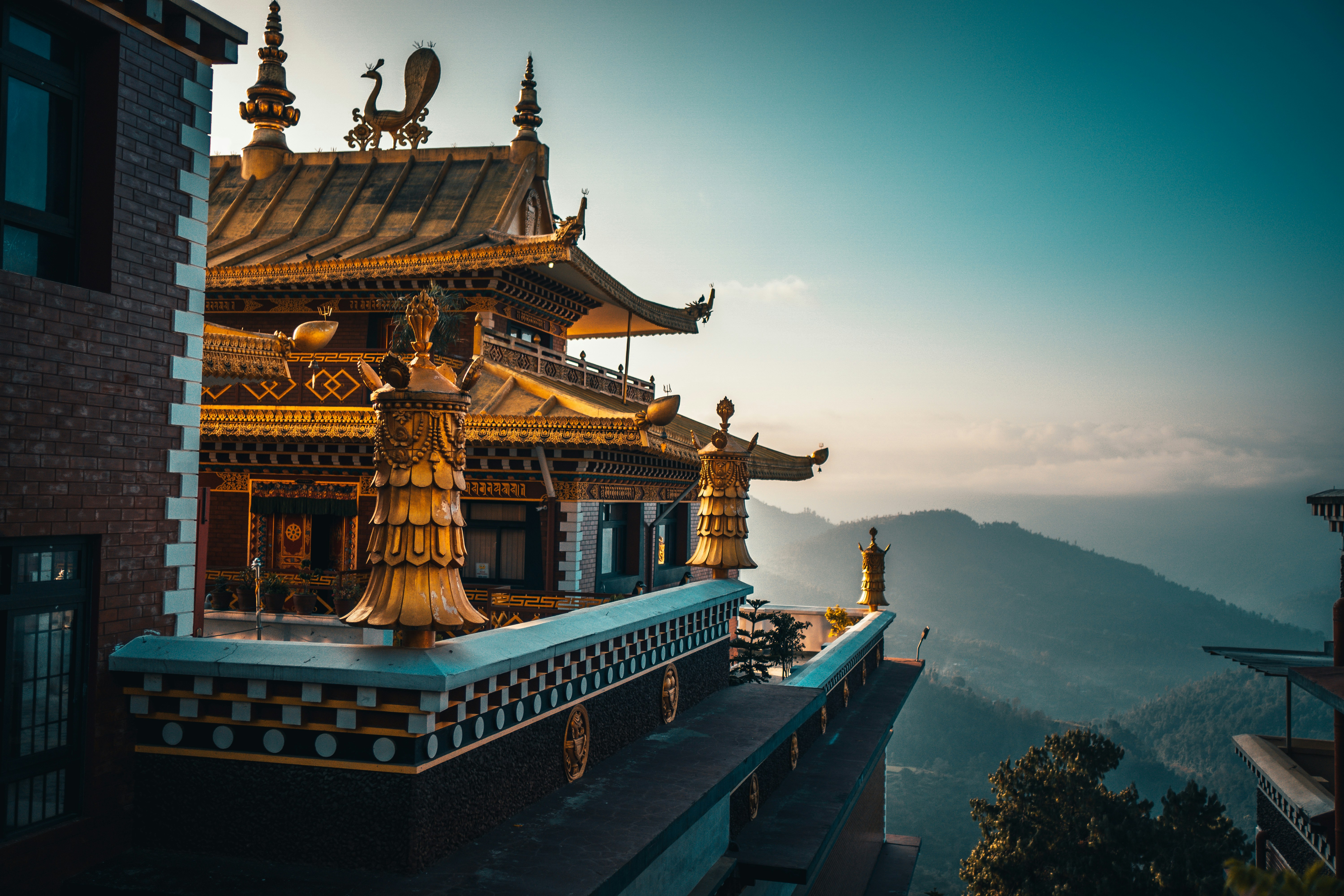 Ornate golden Buddhist temple overlooking misty mountain valleys